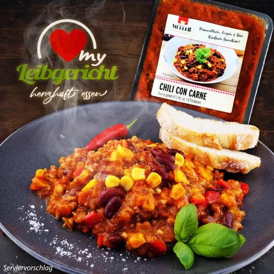 Serviervorschlag von Müller Chili con Carne auf einem Teller mit frischen Kräutern und Brotscheiben