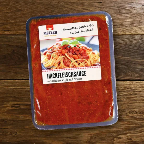 Müller Hackfleischsoße nach Bolognese-Art, fertig verpackt für ca. 2 Personen, auf einem Holztisch