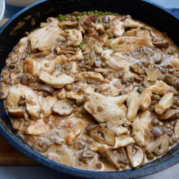 Hähnchengeschnetzeltes mit Steinpilzen in cremiger Sauce einer Pfanne, von oben aufgenommen.