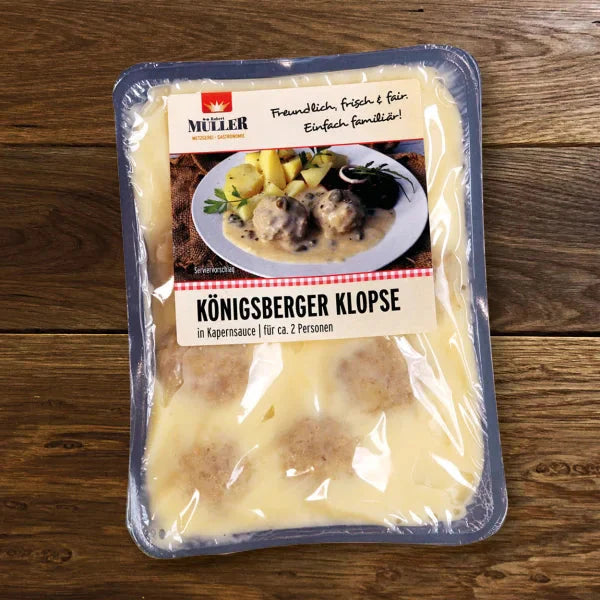 Müller Königsberger Klopse, fertig verpackt in Kapernsauce für ca. 2 Personen, auf einem Holztisch