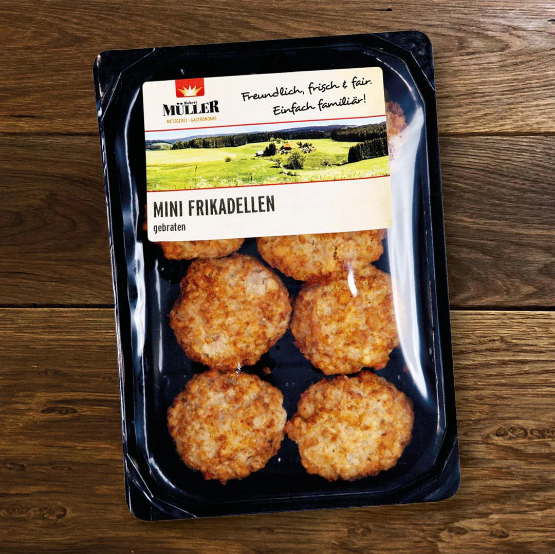 Müller Mini-Frikadellen, fertig verpackt mit 8 Stück pro Packung, auf einem Holztisch