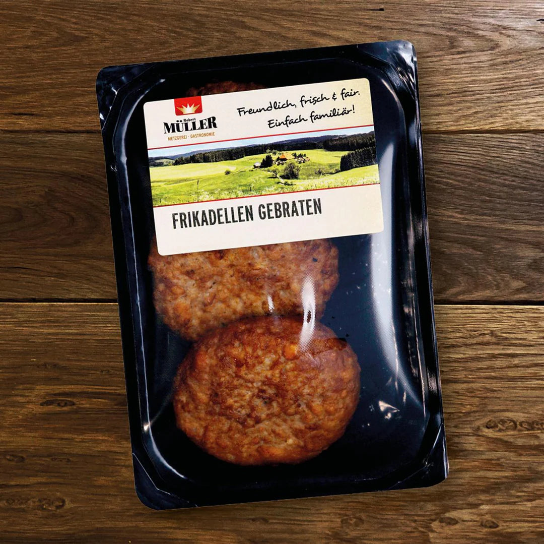 Müller Frikadellen gebraten, fertig verpackt, auf einem Holztisch