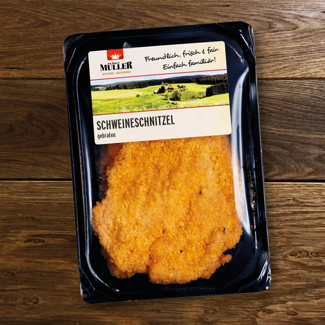 Müller Schweineschnitzel, fertig verpackt mit 2 Stück pro Packung, auf einem Holztisch