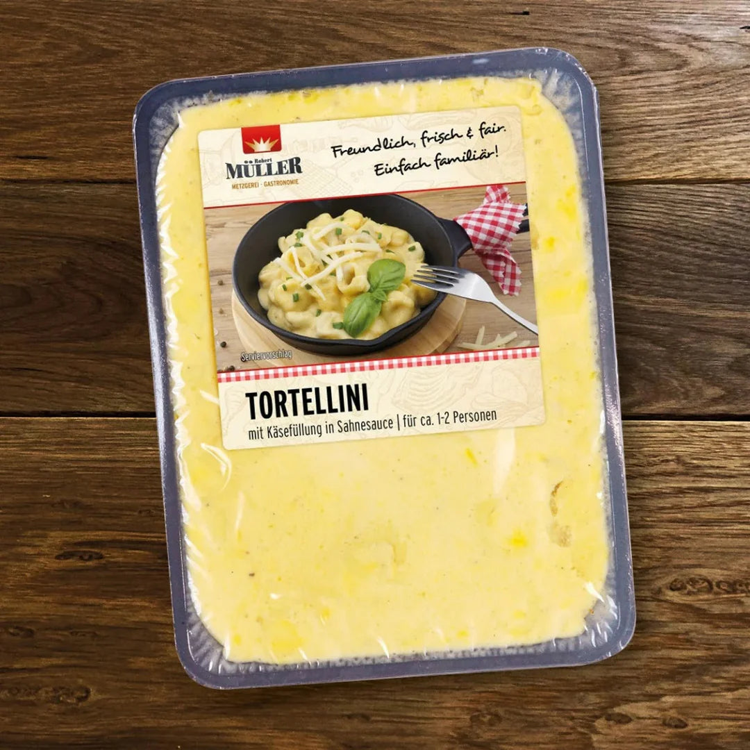 Müller Tortellini mit Käsefüllung in Sahnesauce, fertig verpackt für ca. 1-2 Personen, auf einem Holztisch